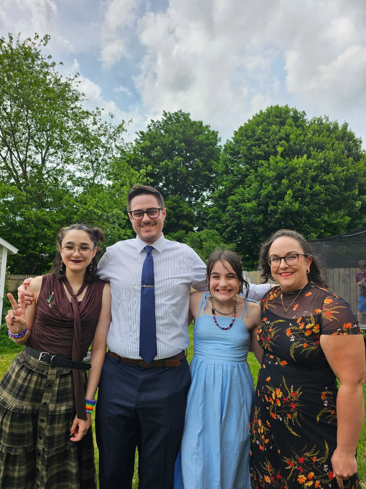 Pastor Ariel standing outdoors with her spouse and two children.